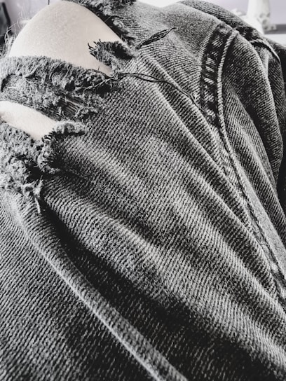 Close-up of a pair of soulsoo denim pants with detailed stitching and a worn-in look.