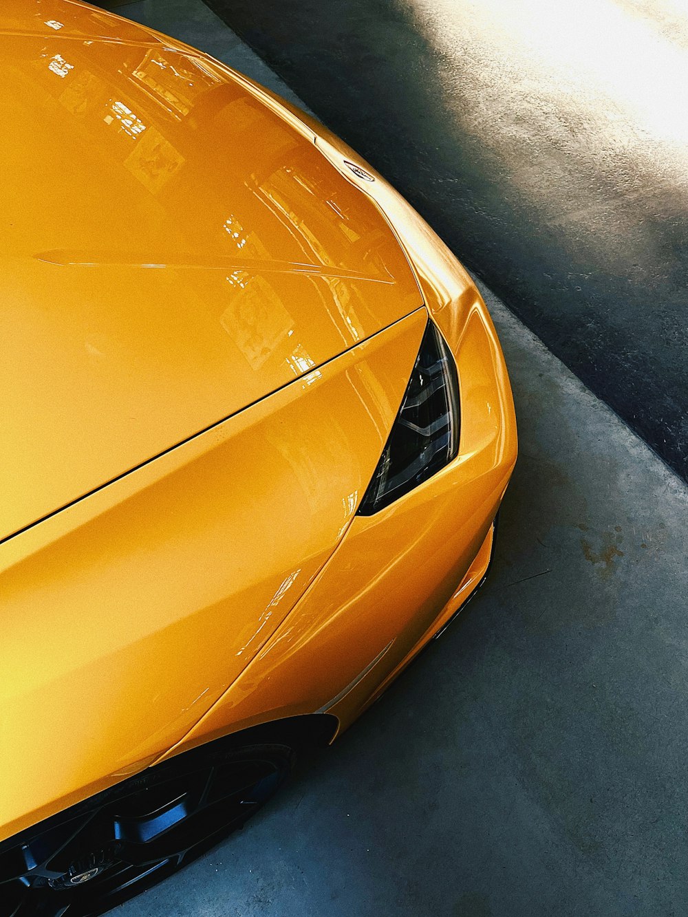 a yellow sports car parked in a garage