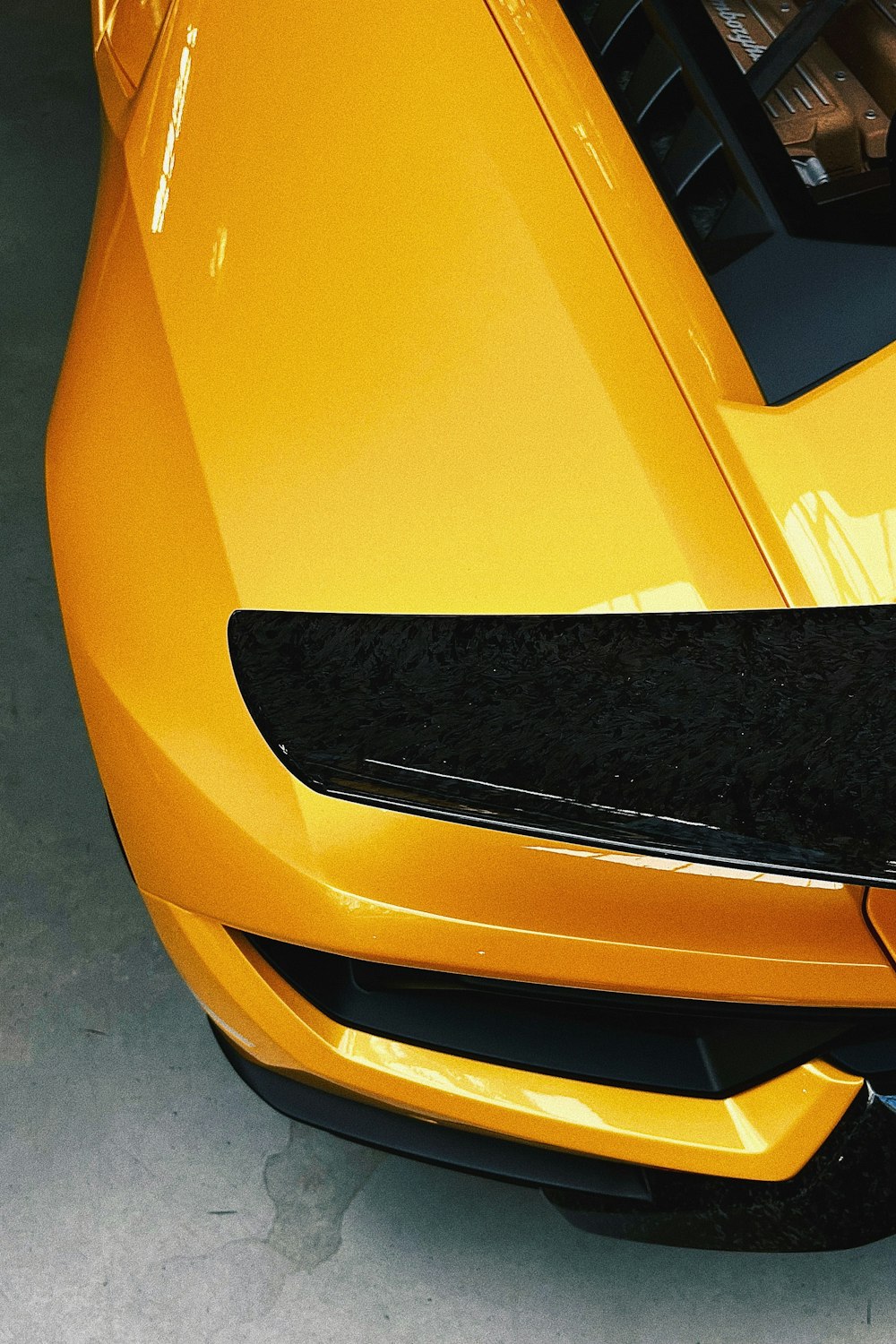 a close up of the hood of a yellow sports car