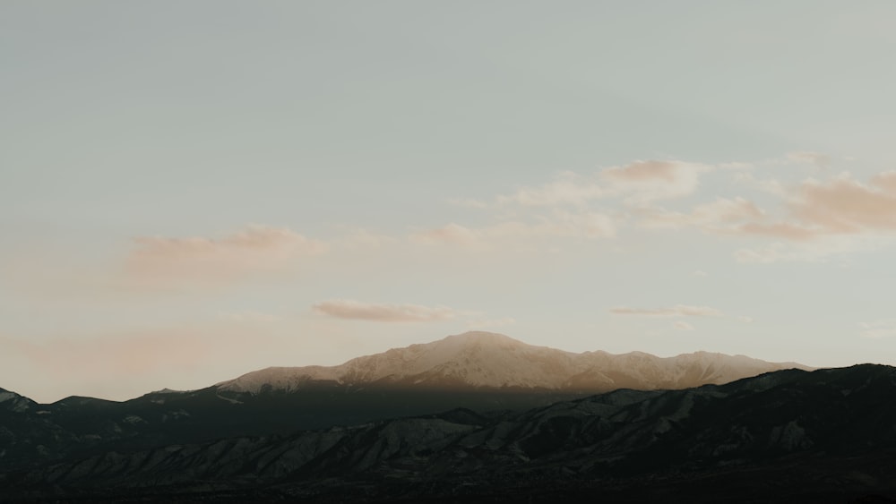 a view of a mountain range with clouds in the sky