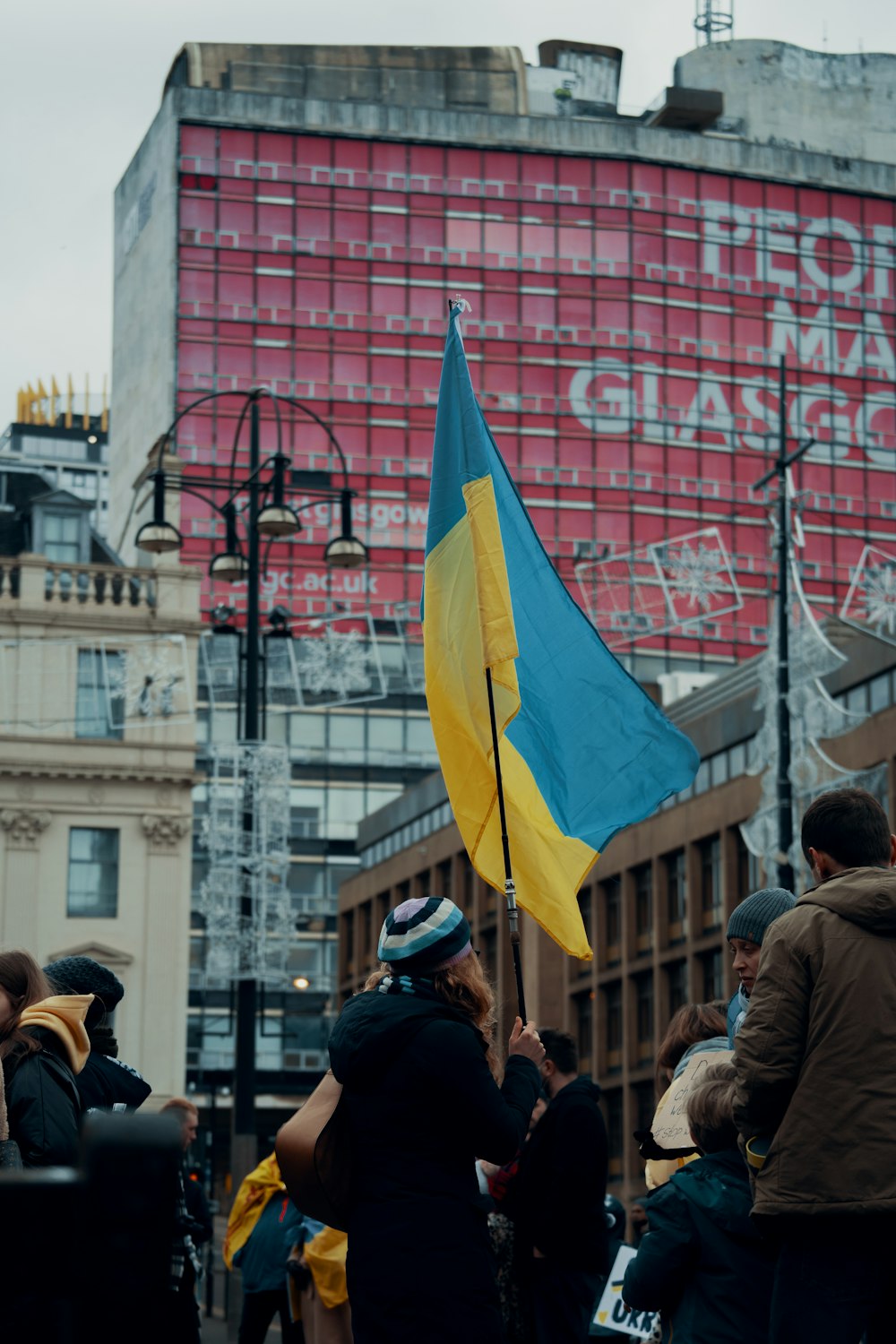 a person holding a flag in front of a building