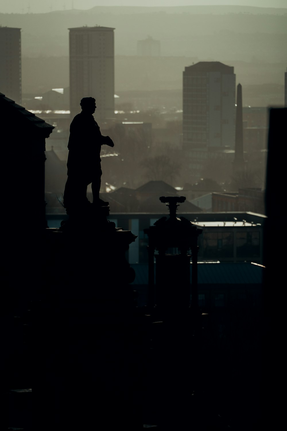 a silhouette of a man standing on top of a building