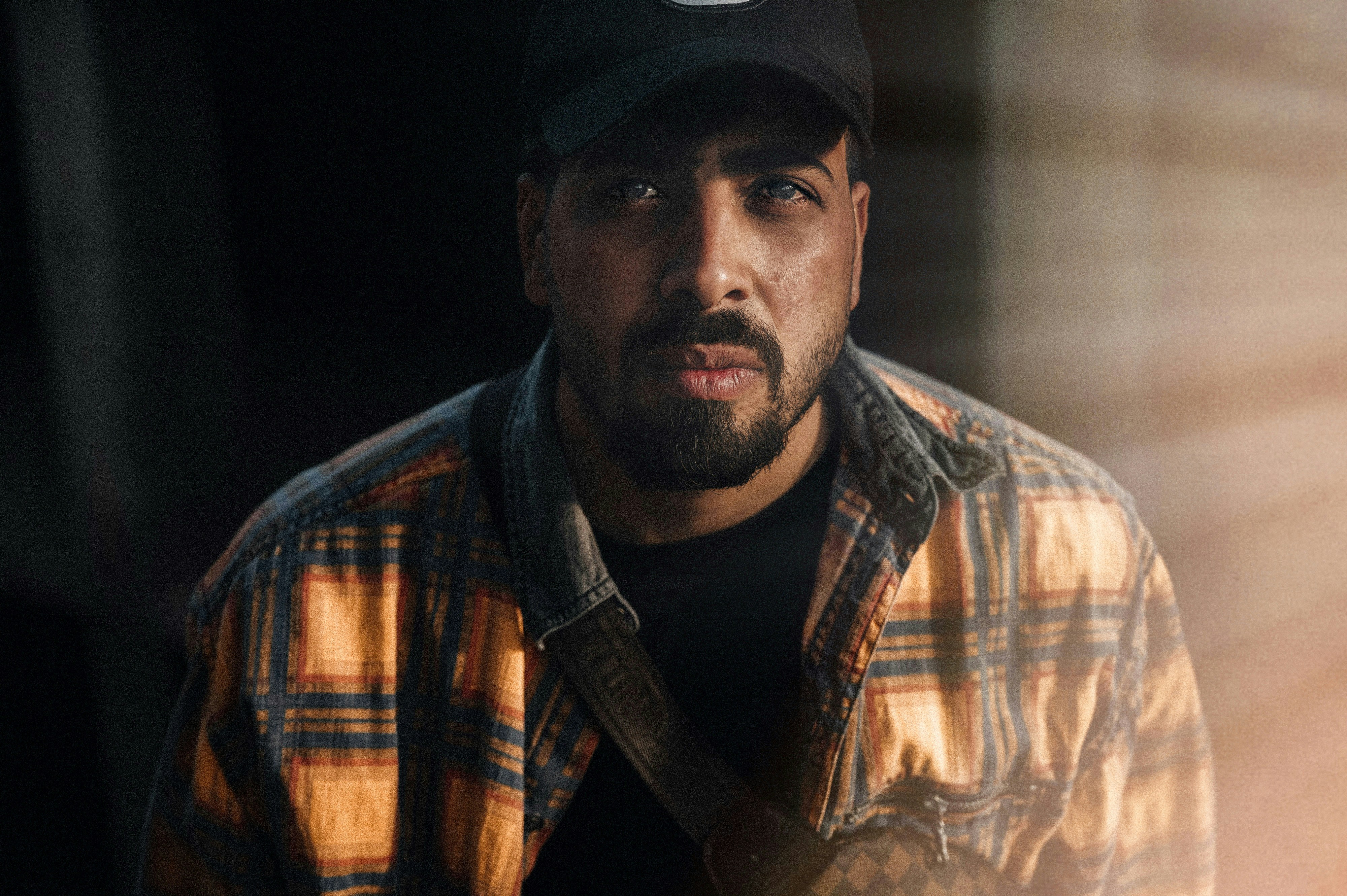 a man wearing a hat and a plaid shirt