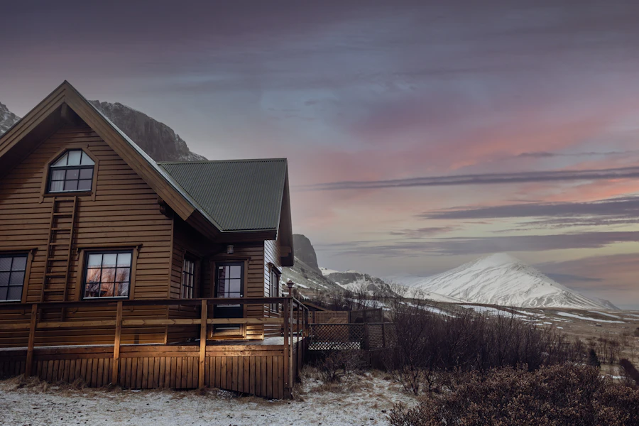 A substantial wooden house with a mountain in the background