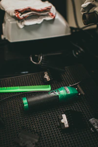 A sleek, modern electric hair clipper glowing with neon blue accents on a dark background.