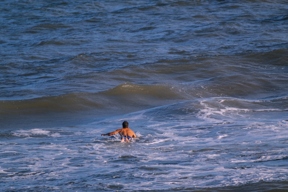 a man riding a wave on top of a surfboard