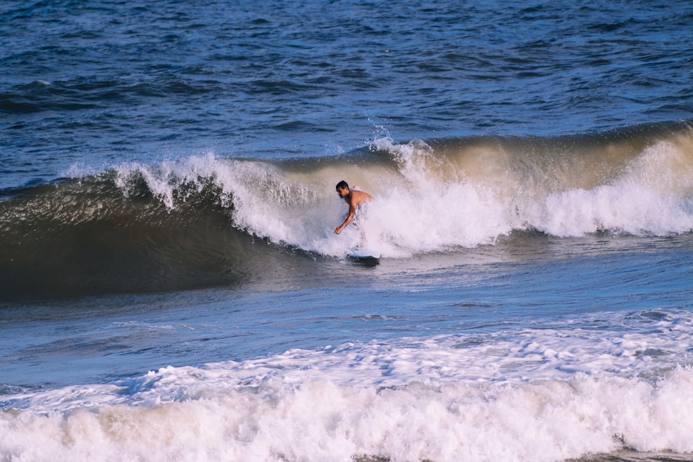 a man riding a wave on top of a surfboard