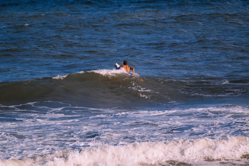 a man riding a wave on top of a surfboard