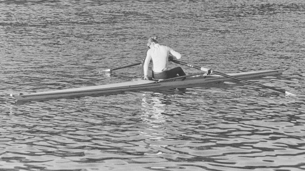 a man rowing a boat on a body of water