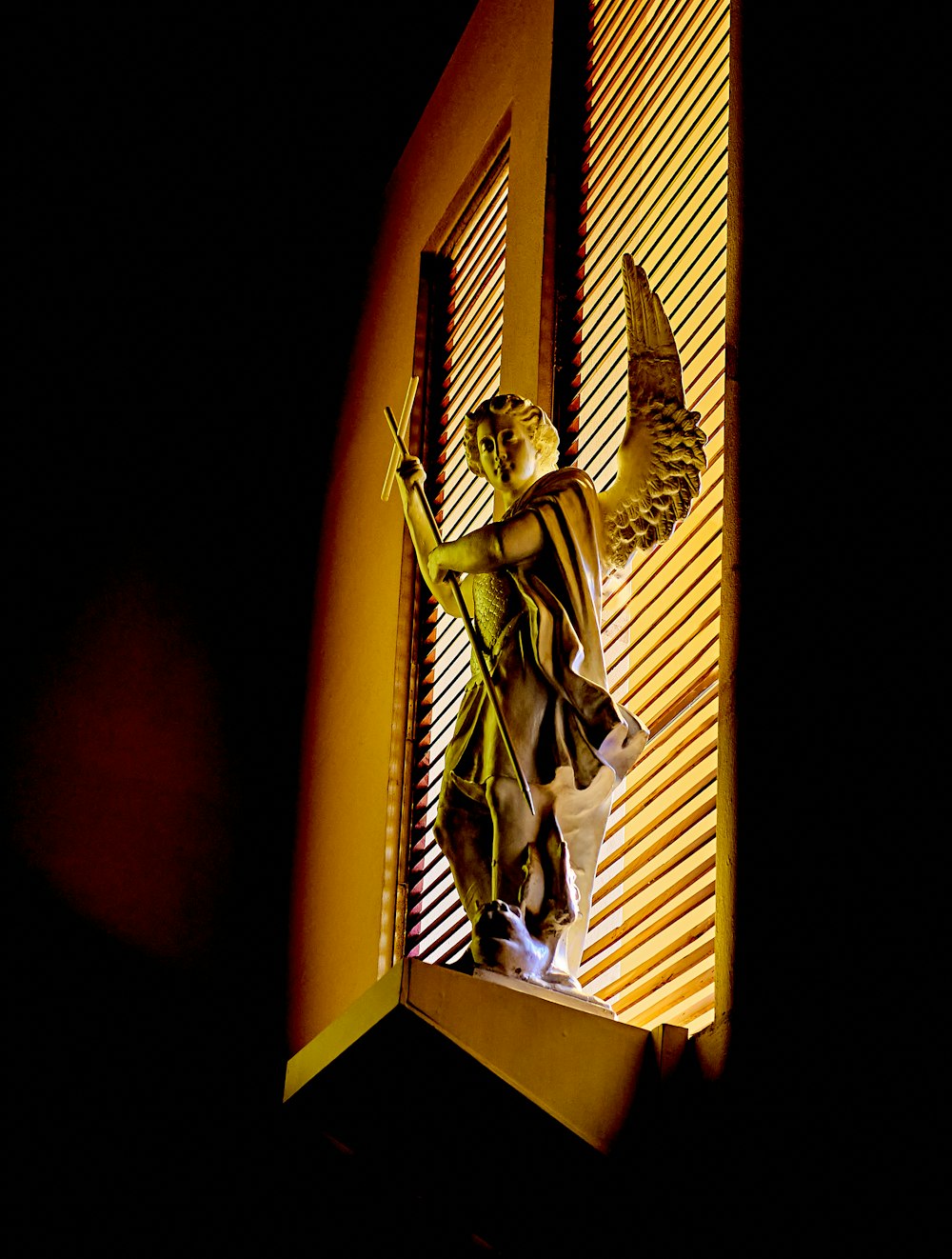 a statue of a woman holding a bird on top of a window sill