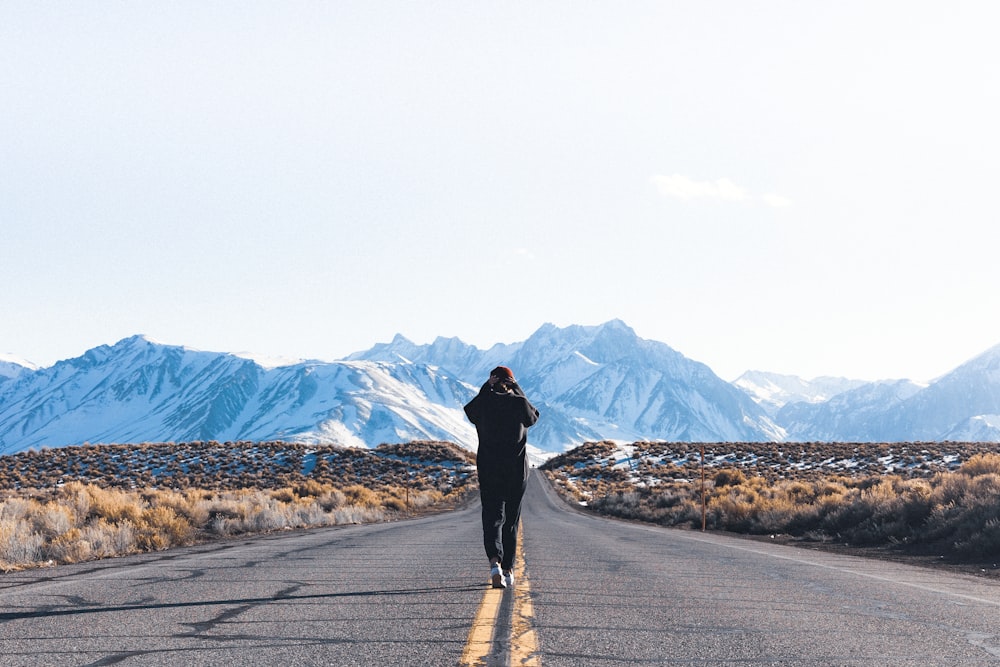 a person walking down the middle of a road