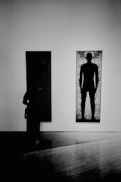 a person standing in front of a painting on a wall