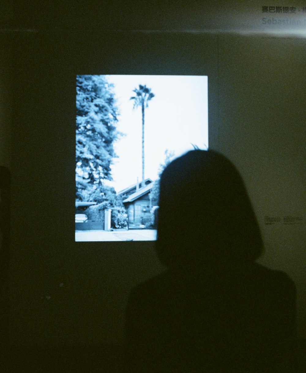 a person standing in front of a television in a dark room