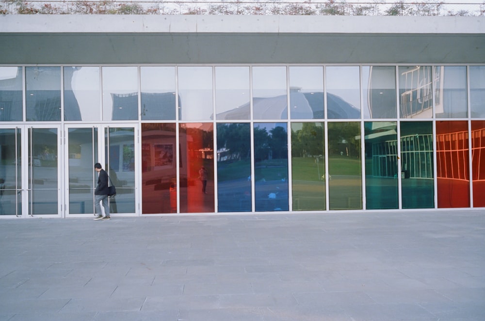 a person walking past a building with many windows