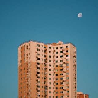 a tall building with a half moon in the sky