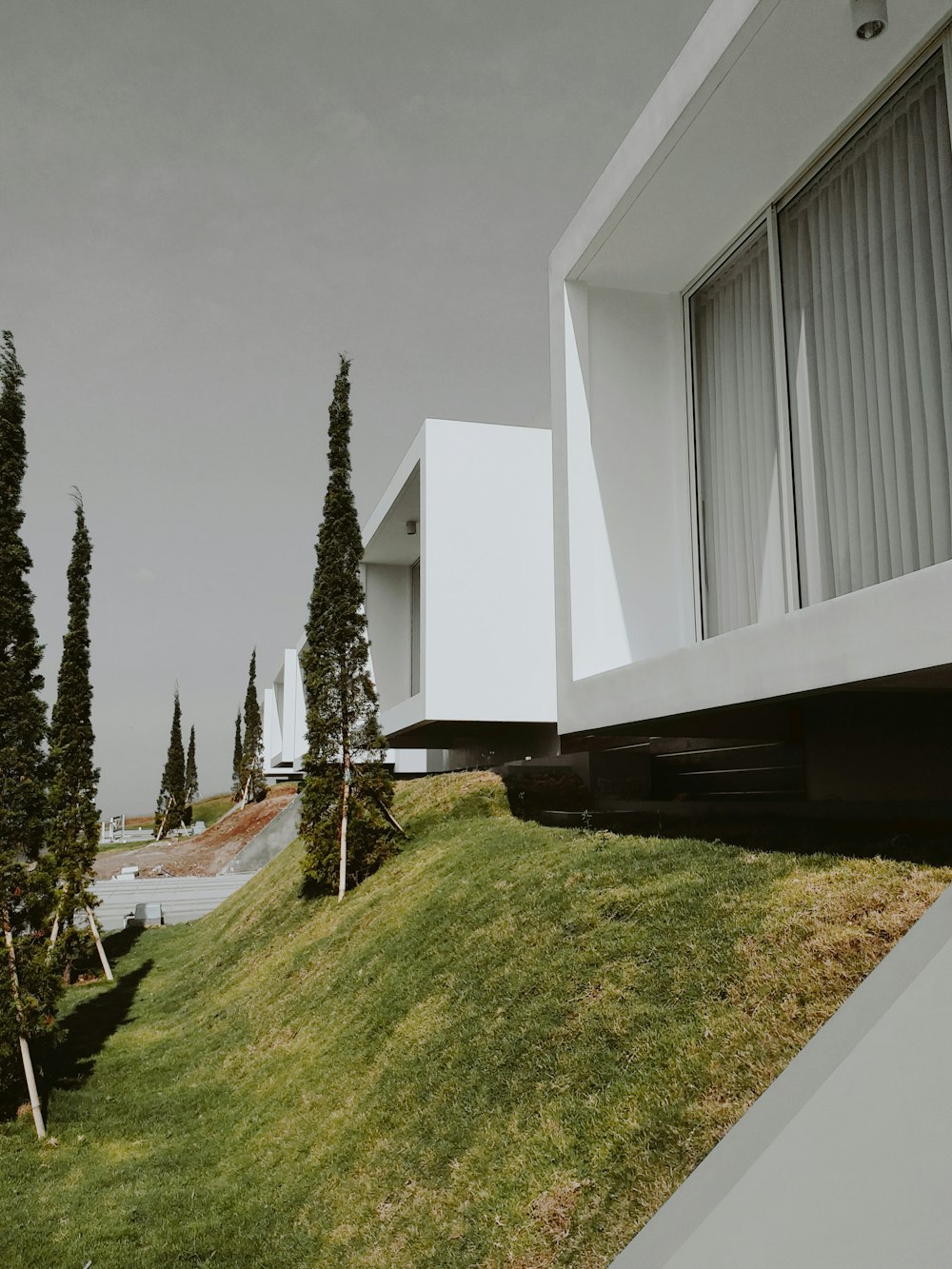 a house on a hill with trees in the background