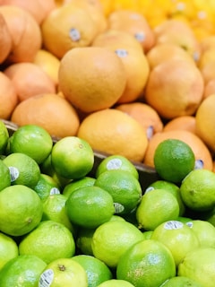 a pile of limes and oranges sitting next to each other