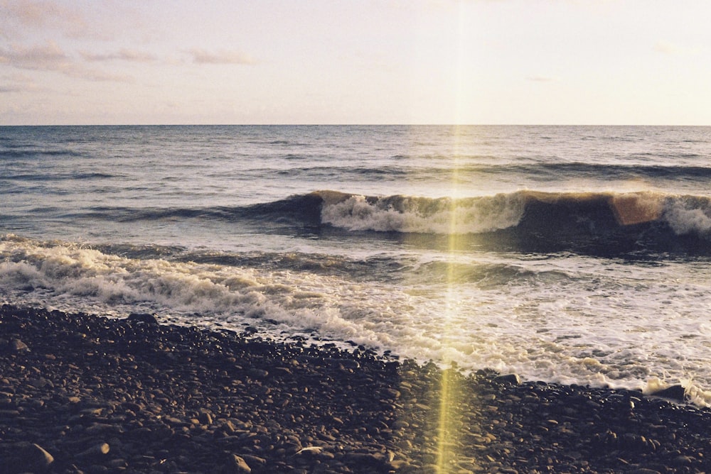 the sun shines brightly on a rocky beach