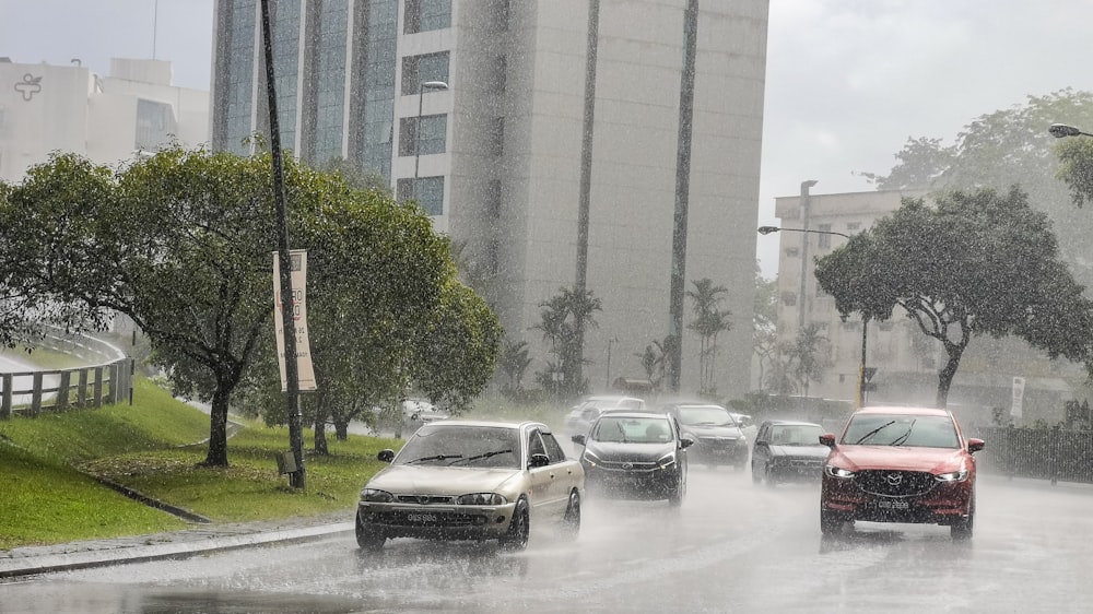 a bunch of cars driving down a street in the rain