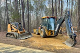 a tractor and a bulldozer are parked on a dirt road