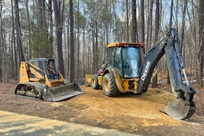 a tractor and a bulldozer are parked on a dirt road