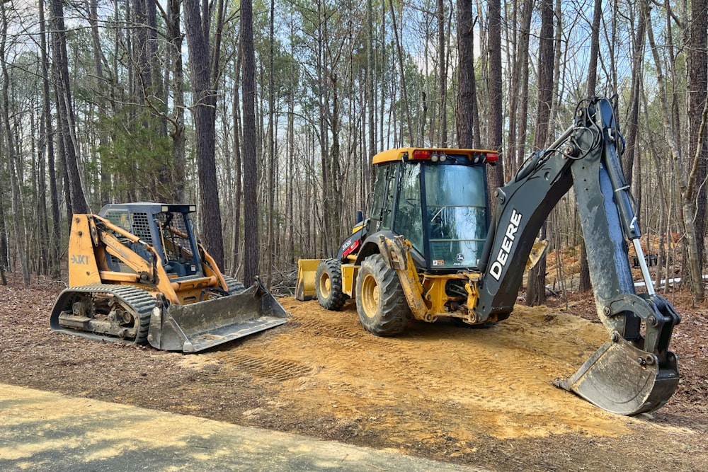 a tractor and a bulldozer are parked on a dirt road