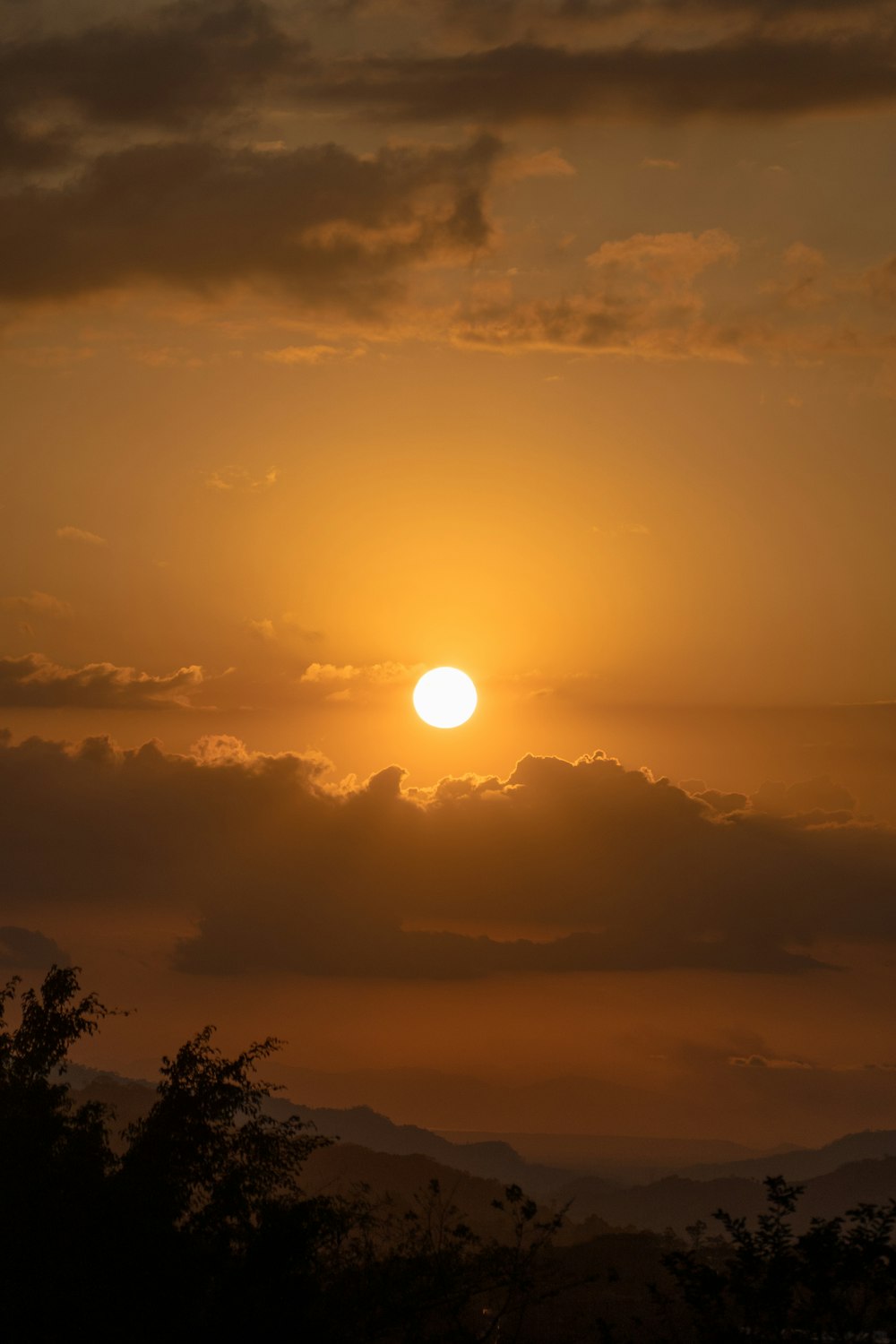 the sun is setting over a mountain range