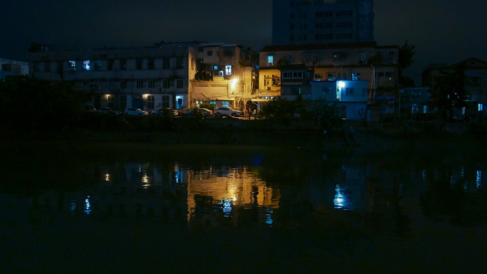 a city at night with a body of water in front of it