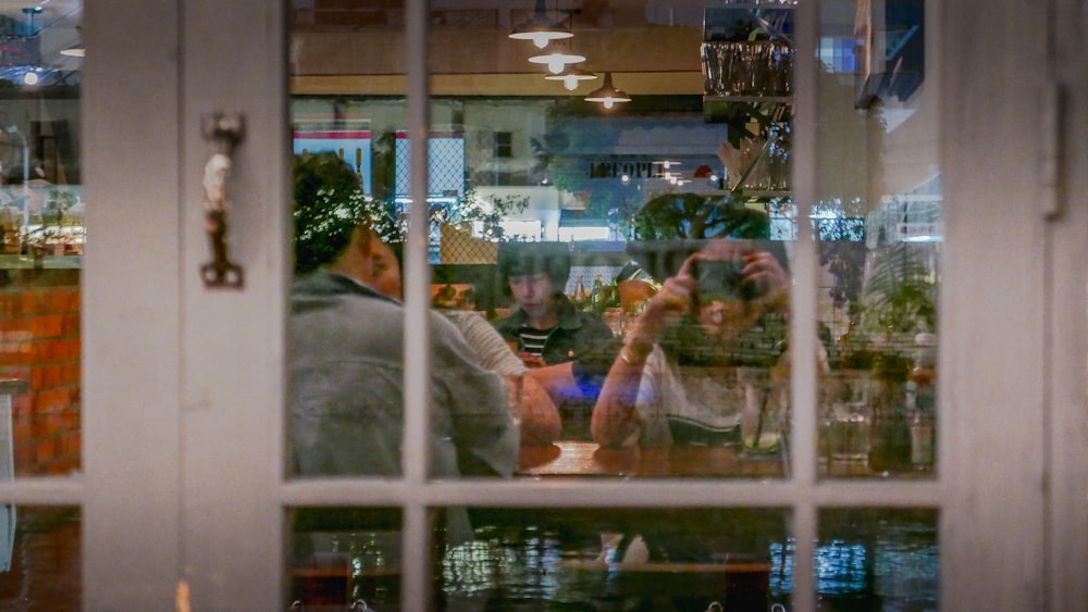 a couple of people sitting at a table in front of a window