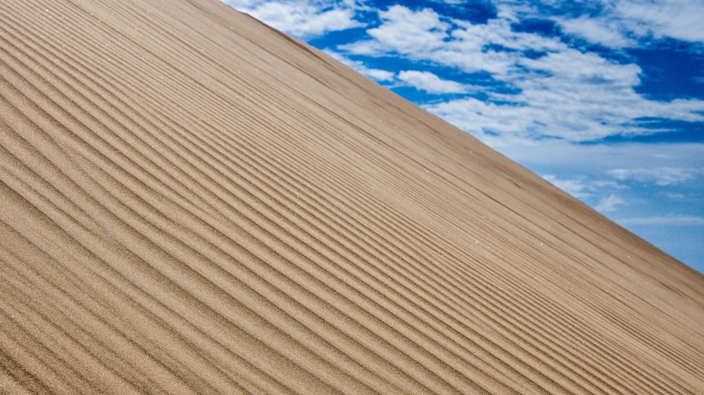 a person riding a surfboard on top of a sand dune