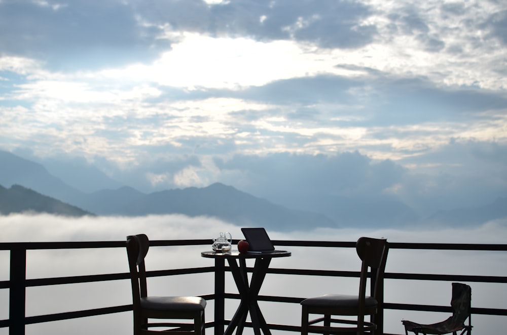 a couple of chairs sitting next to each other on a balcony