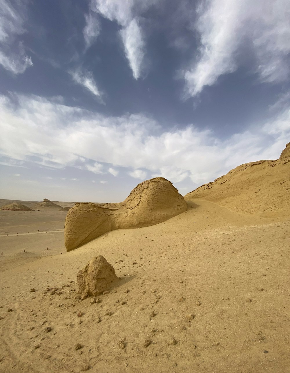 a large rock in the middle of a desert