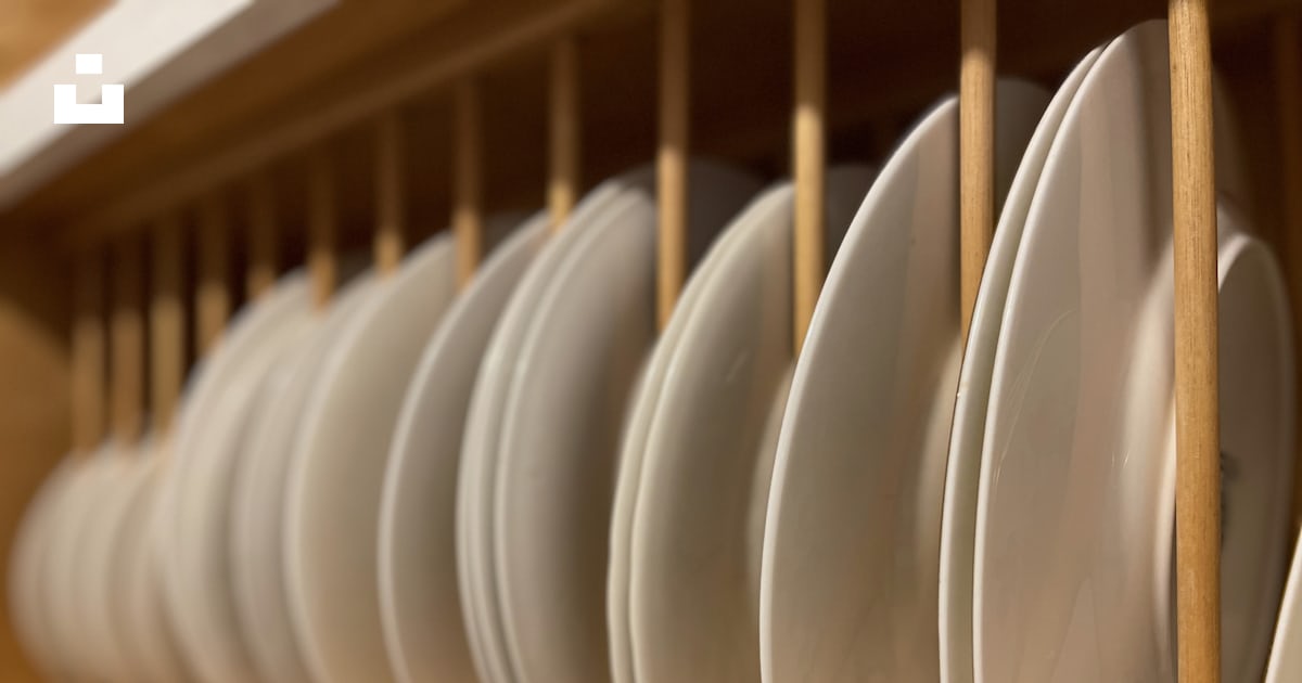 A bunch of white plates that are on a shelf photo – Free Plate rack ...