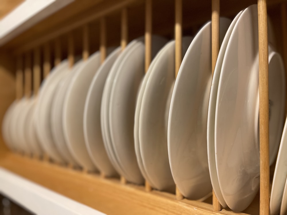a bunch of white plates that are on a shelf