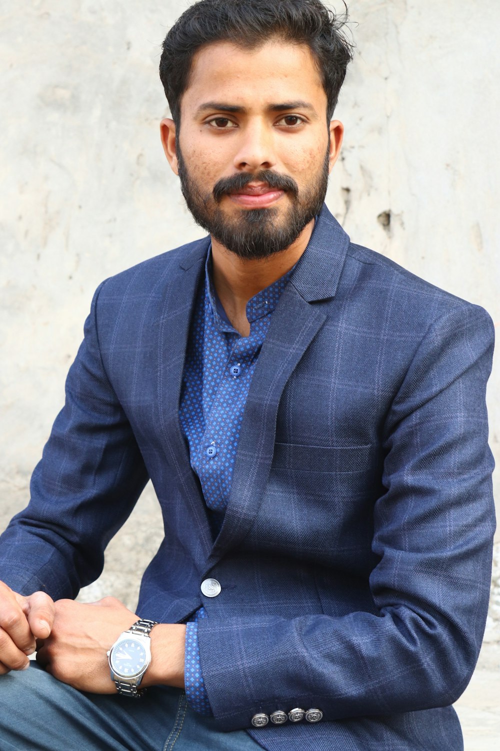 a man in a blue suit sitting down