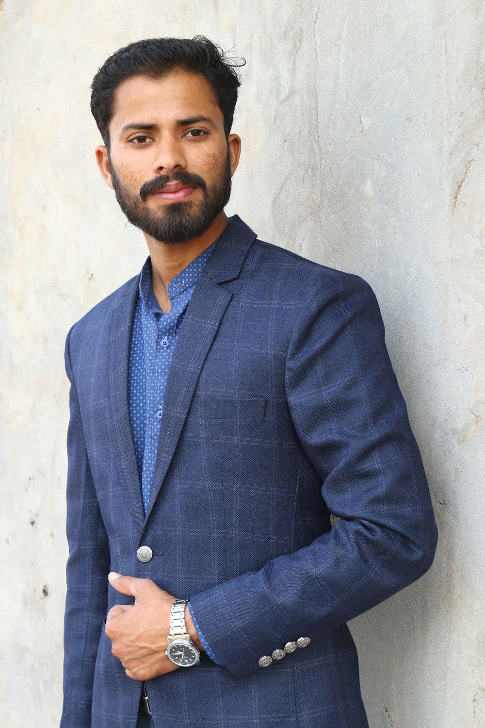 un homme avec une barbe portant un costume bleu