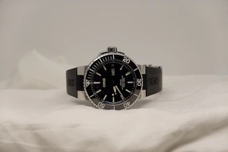 a watch sitting on top of a white sheet