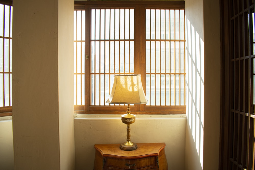 a lamp sitting on top of a table next to a window