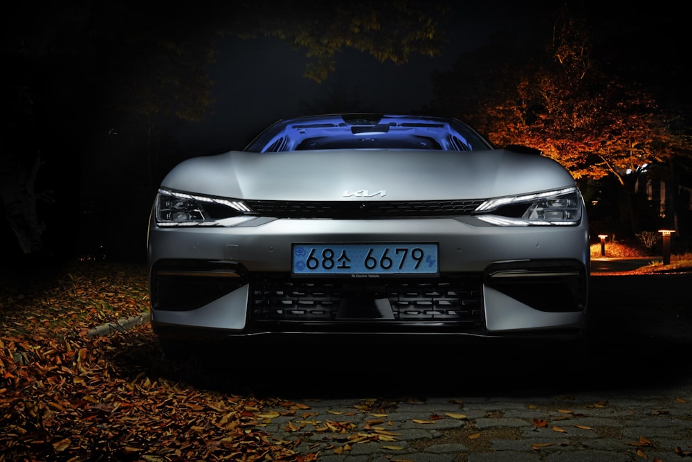 a silver car parked in a driveway at night