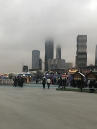 Young professionals networking at an international career fair with city skyline in the background.