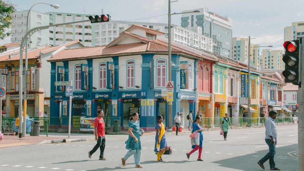 a group of people walking across a street