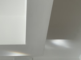 Minimalist wall with smooth, high-precision plaster finish in soft natural light.
