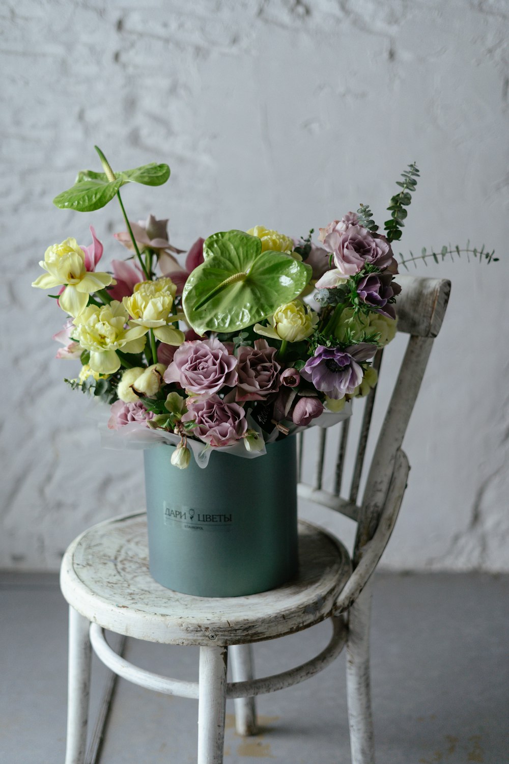 a chair with a vase of flowers sitting on top of it