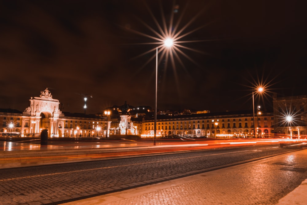 a city street at night with a clock tower in the background