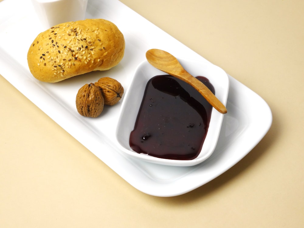 a white tray with a spoon and some food on it