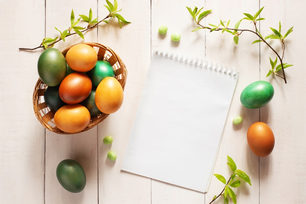 a basket of eggs and a notepad on a table