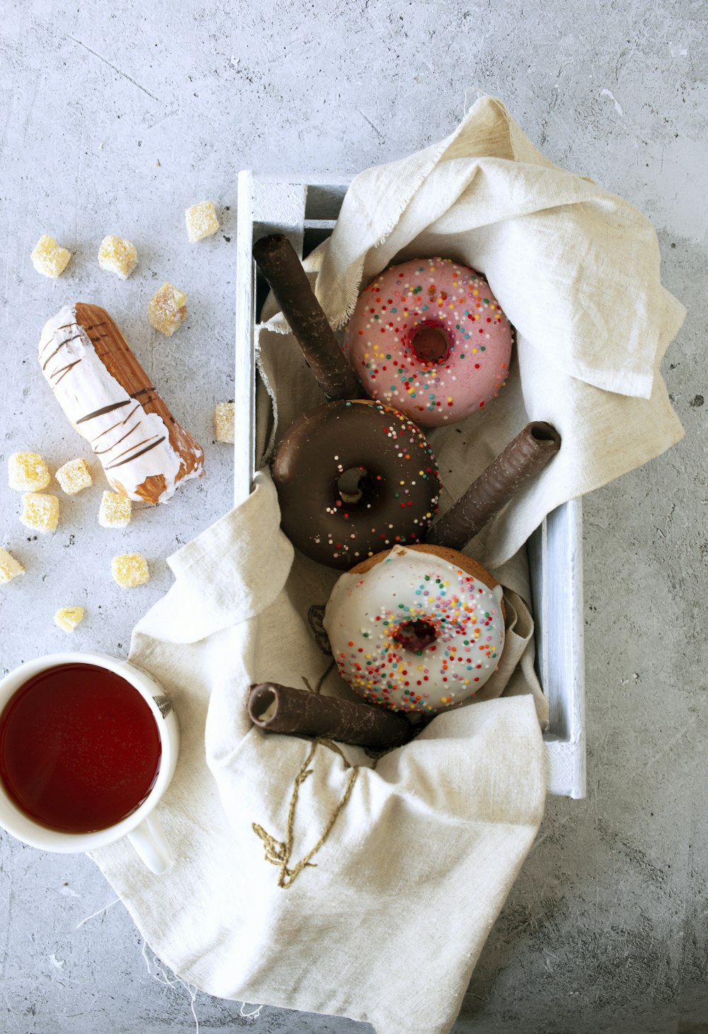 a box filled with donuts next to a cup of tea