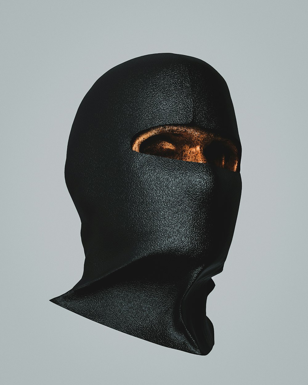 a person wearing a black mask with gold eyes