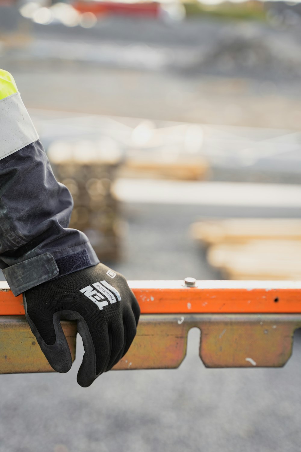 a person wearing a safety glove holding onto a rail