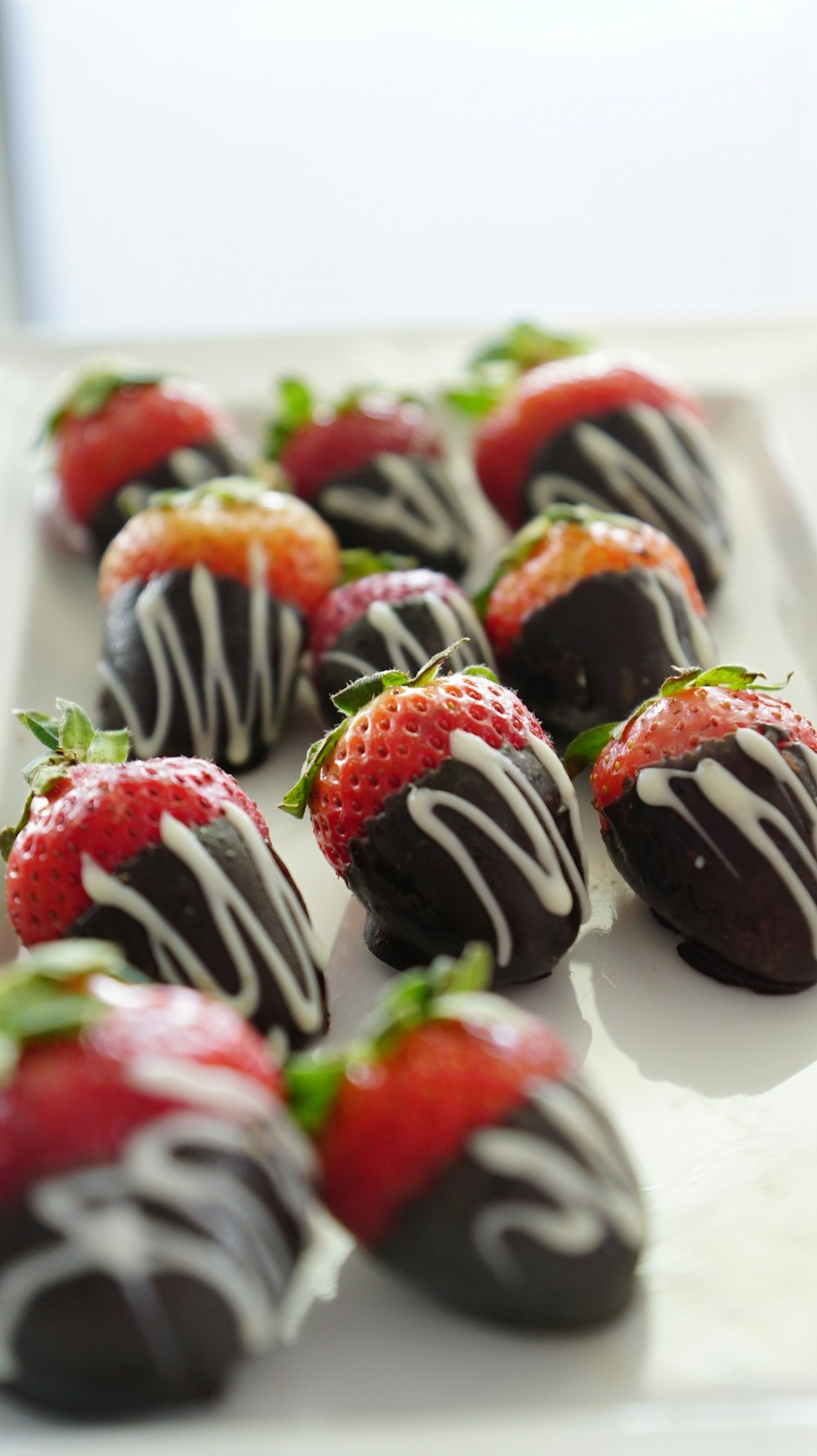 a plate of chocolate covered strawberries on a table